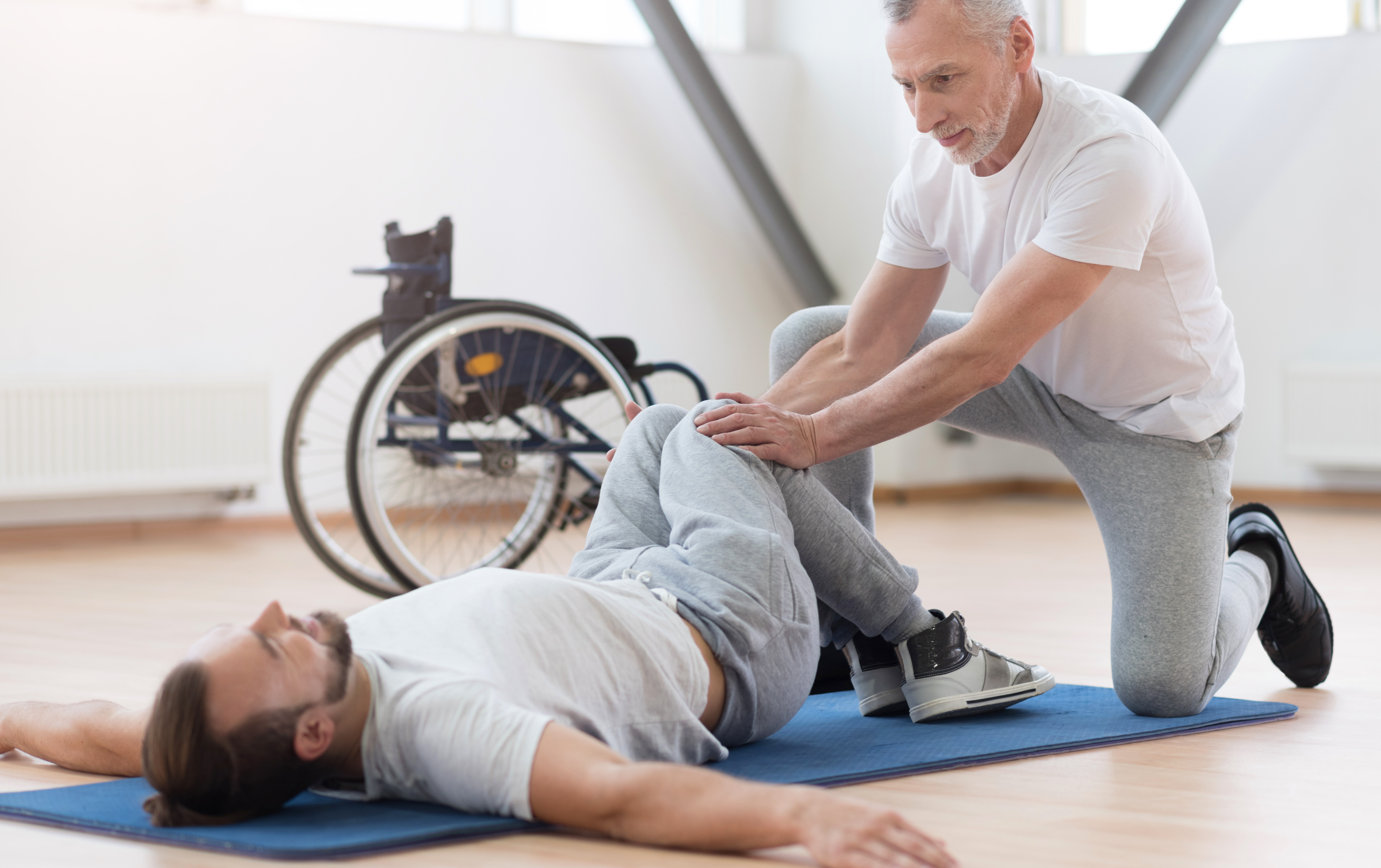 Physiotherapeut mit einem Patient im Rollstuhl
