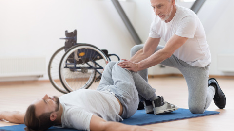 Mann im Rollstuhl bei der Physiotherapie