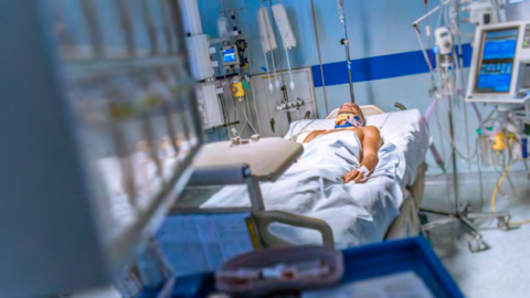 Person im Krankenbett an Schäuchen